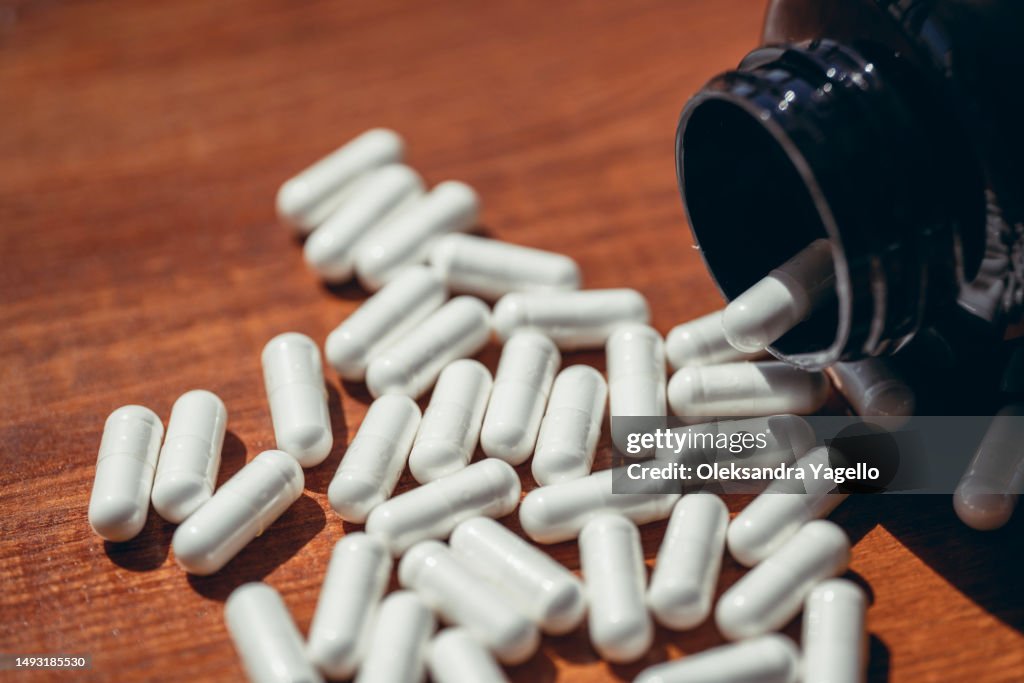 Vegetable capsules with white medicine inside. Supplements close up