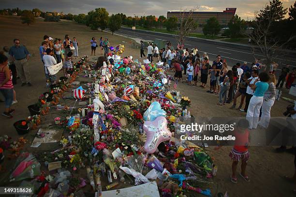 People visit a memorial setup across the street from the Century 16 movie theatre where James Holmes is suspected of a mass shooting on July 26, 2012...