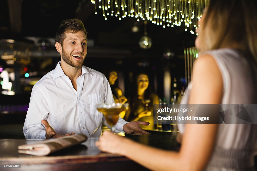 Woman talking to bartender at bar