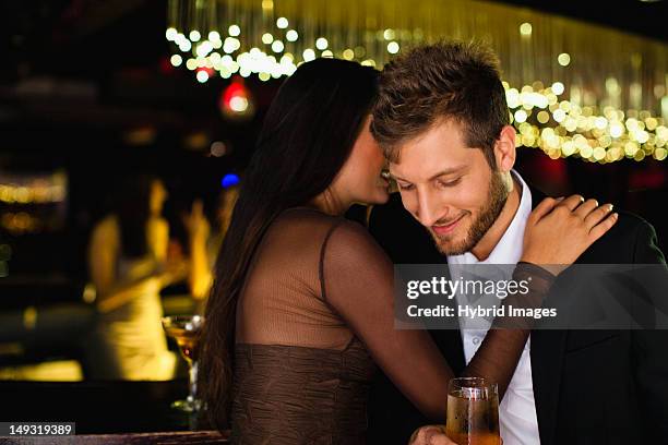 smiling couple whispering at bar - conquista fotografías e imágenes de stock