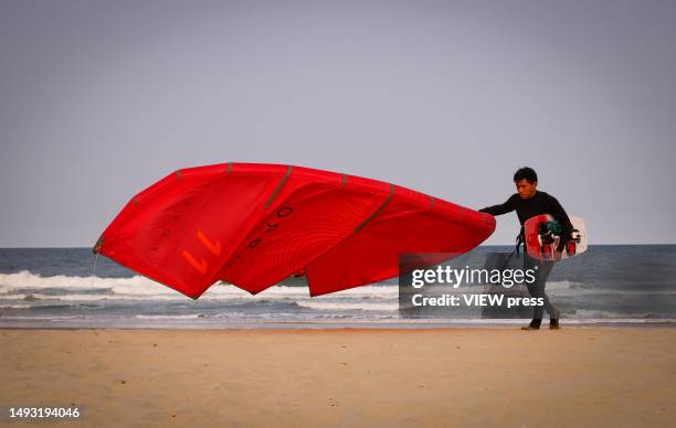 Man carries kite boarding gear beach on May 24, 2023 in Avon Beach New Jersey. The Jersey shore is getting ready to open business' for the Summer...