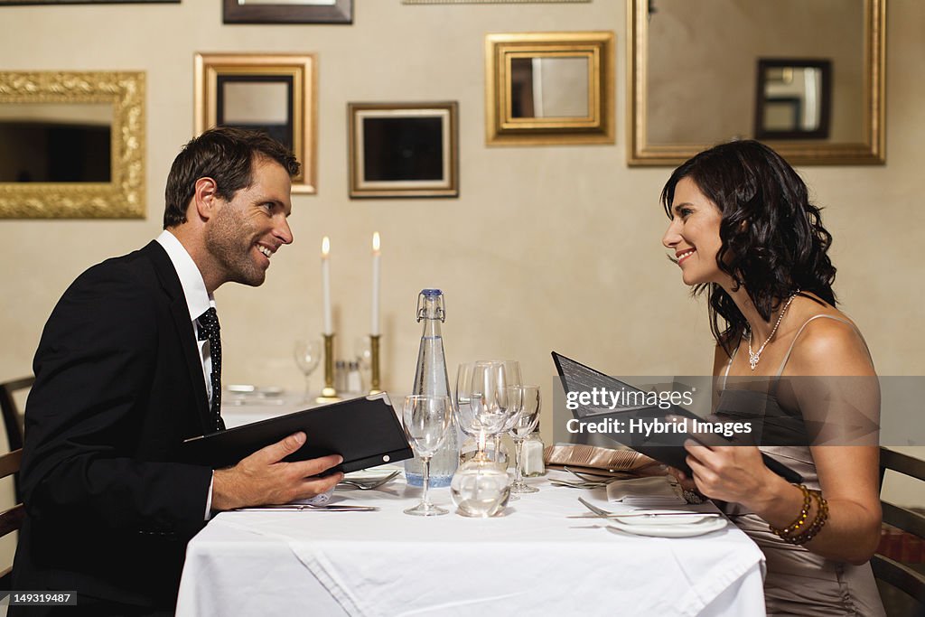 Couple examining menus in restaurant