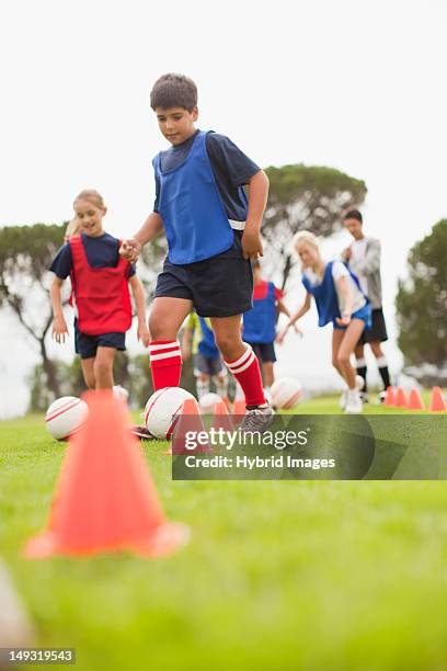 childrens soccer team training on pitch - kids sports training stock pictures, royalty-free photos & images