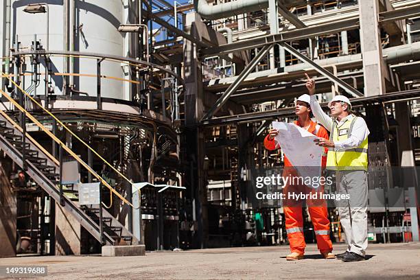 workers talking at oil refinery - coordinated effort stock pictures, royalty-free photos & images