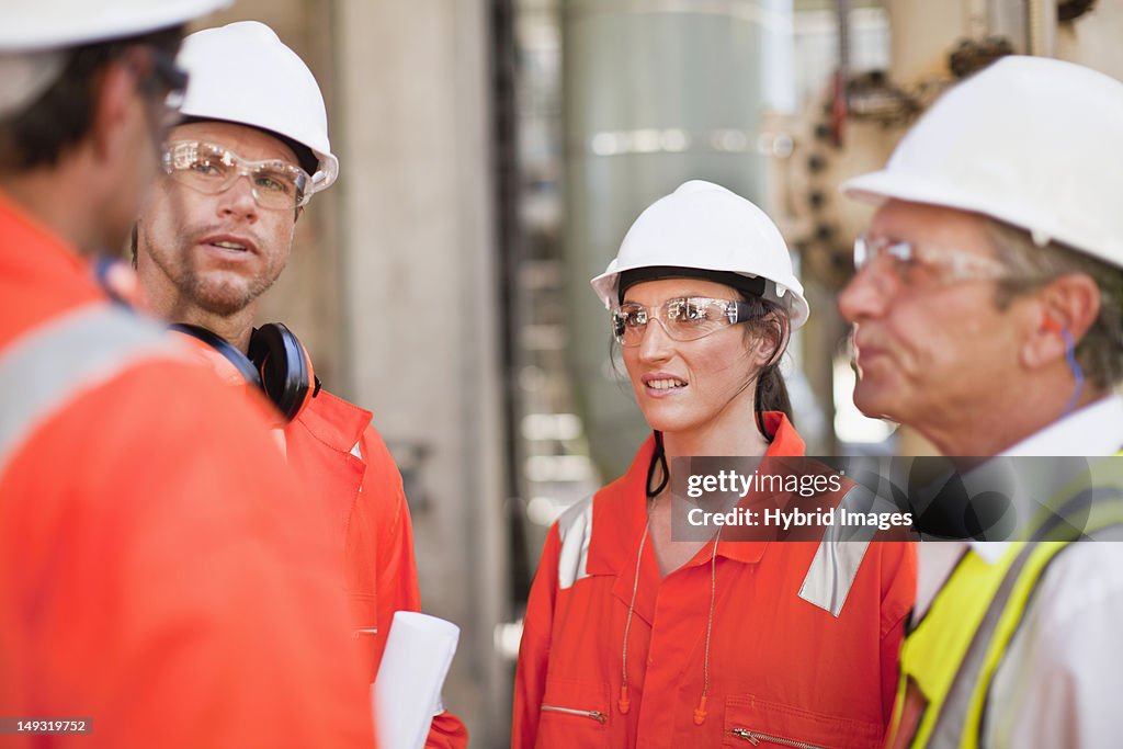 Trabajadores pasos en la refinería de petróleo