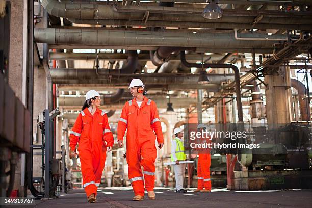 workers walking at oil refinery - oil industry stock-fotos und bilder