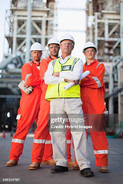 workers standing at oil refinery - oil rig worker woman stock pictures, royalty-free photos & images