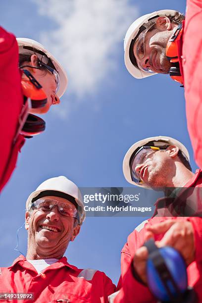 smiling workers talking outdoors - red jumpsuit stock pictures, royalty-free photos & images