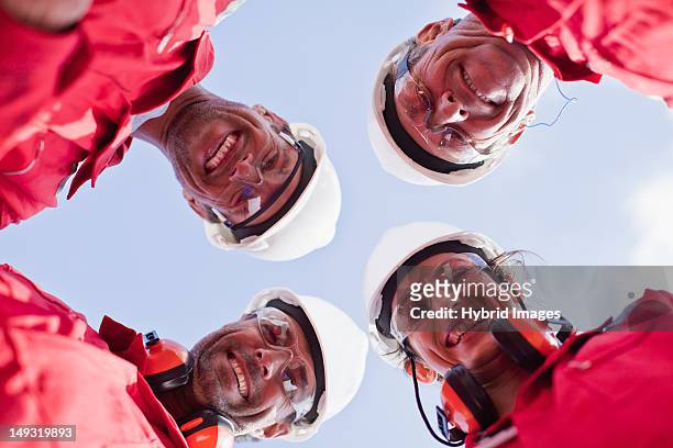 smiling workers posing outdoors - red jumpsuit stock pictures, royalty-free photos & images
