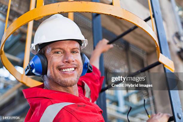 worker climbing ladder at oil refinery - oil rig worker stock pictures, royalty-free photos & images