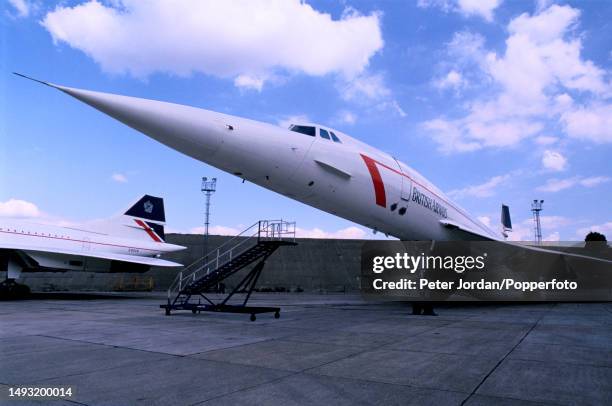 Two British Airways Concorde supersonic aircraft parked on an apron outside BA's service hangar at Heathrow Airport in west London in 1990. The...