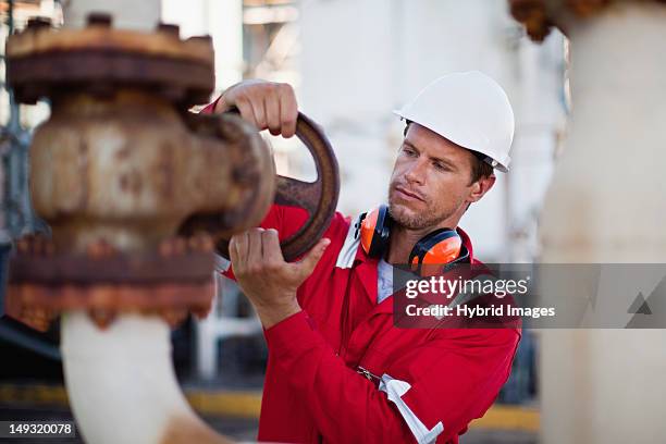 worker adjusting gauge at chemical plant - gas plant stock pictures, royalty-free photos & images