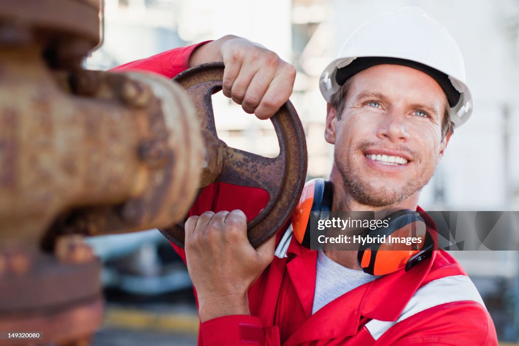 Worker adjusting gauge at chemical plant