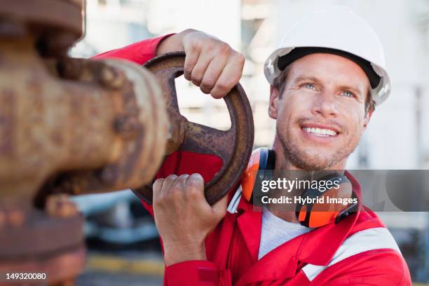 worker adjusting gauge at chemical plant - oil worker stock pictures, royalty-free photos & images