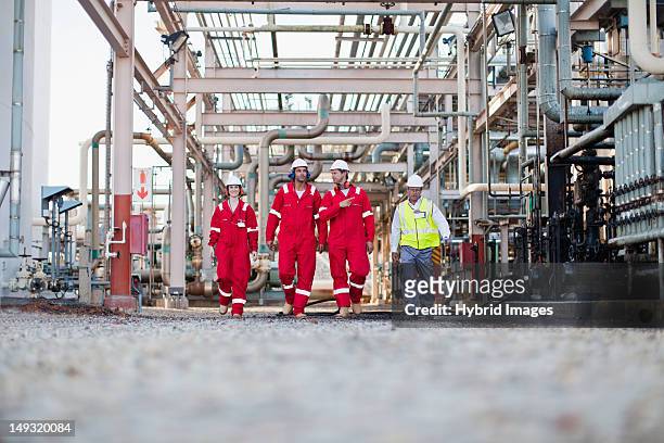 workers walking at chemical plant - oil refinery stock pictures, royalty-free photos & images