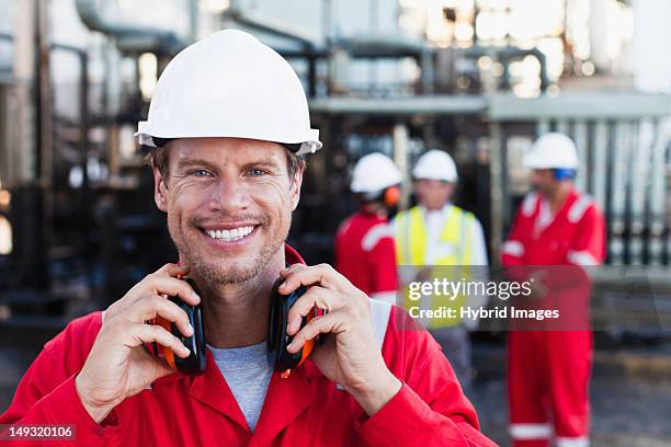 worker standing at chemical plant - ohrenschützer stock-fotos und bilder