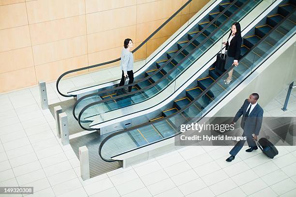business people in lobby area - rolltreppe von oben stock-fotos und bilder