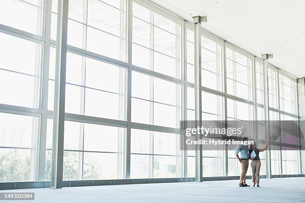 business people talking in lobby - distant meeting stock pictures, royalty-free photos & images