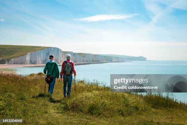 two friends hiking together at seven sisters cliffs on the english south coast - sussex stock pictures, royalty-free photos & images