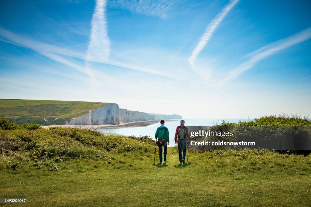 Two friends hiking together at Seven Sisters cliffs on the English south coast