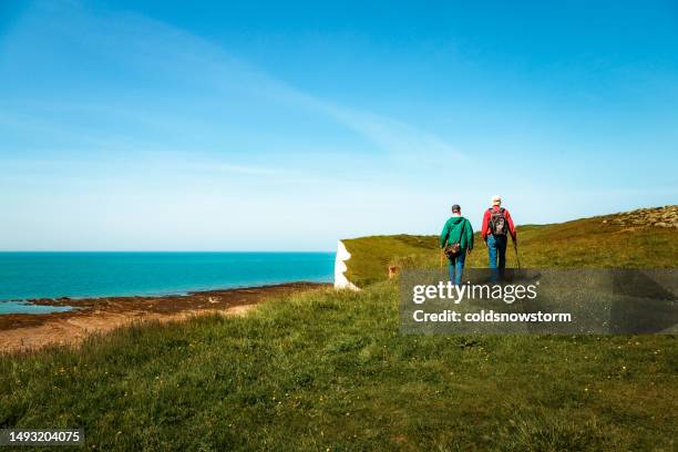 two friends hiking together at seven sisters cliffs on the english south coast - seven sisters klif stockfoto's en -beelden