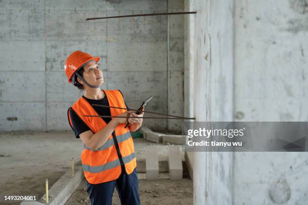 an asian female engineer inspects the quality of a commercial building construction site under construction - employee engagement survey stock pictures, royalty-free photos & images