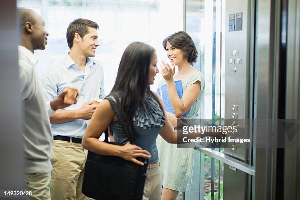 business people riding glass elevator - aufzug business stock-fotos und bilder