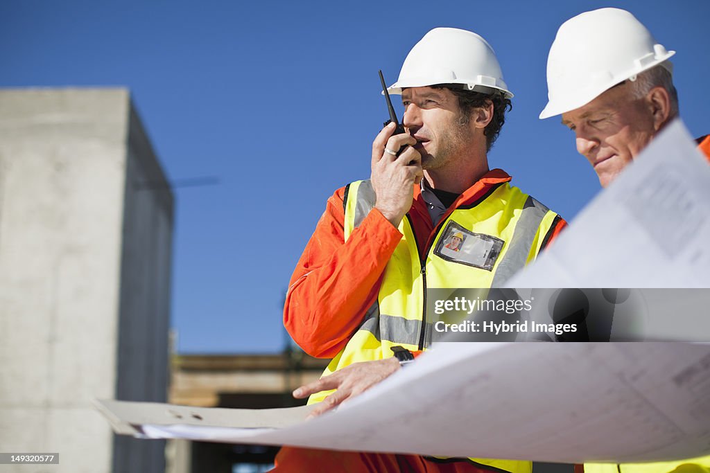 Workers reading blueprints on site