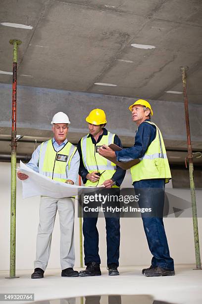 workers reading blueprints on site - conference 2012 day 3 stockfoto's en -beelden