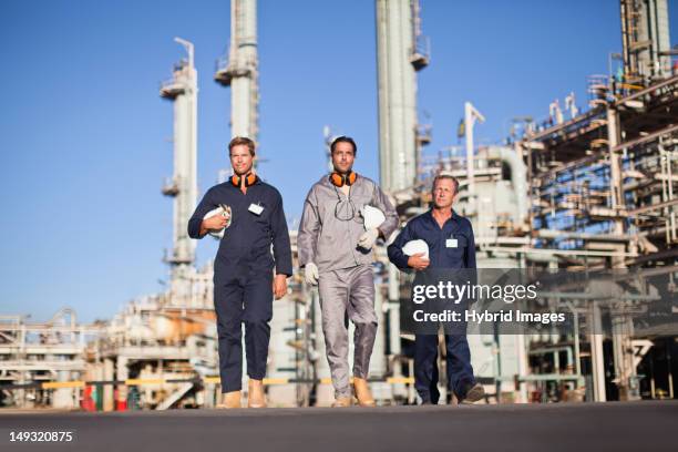 workers walking at oil refinery - overall stockfoto's en -beelden