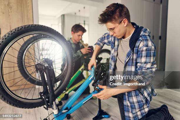 teenage boys cleaning bicycles at home - apartment bike stock pictures, royalty-free photos & images