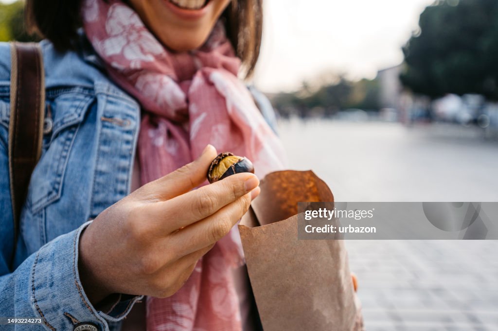 Young Woman Eating Roasted Chestnuts On The Street In Istanbul