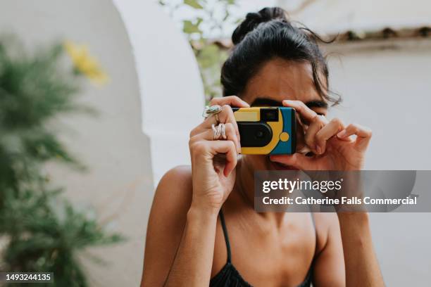 a woman takes a photo with a disposable camera - gifted movie stock-fotos und bilder