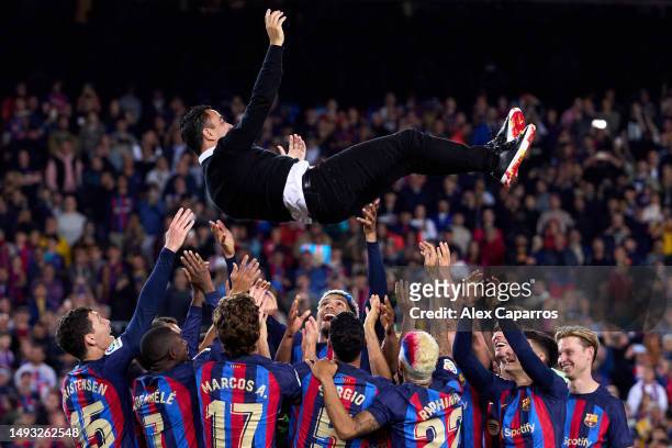 Head Coach Xavi Hernandez of FC Barcelona is thrown in the air by his players as they celebrate after being crowned LaLiga Santander Champions after...