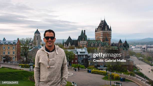 portrait of man in front of le chateau frontenac - chateau frontenac hotel stock pictures, royalty-free photos & images