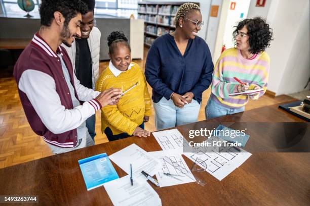 kolleginnen und kollegen lernen gemeinsam in der bibliothek - bauingenieurwesen stock-fotos und bilder
