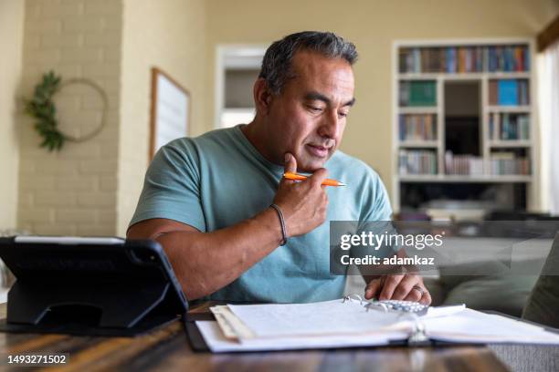 mature man working from home using a computer - skatt bildbanksfoton och bilder