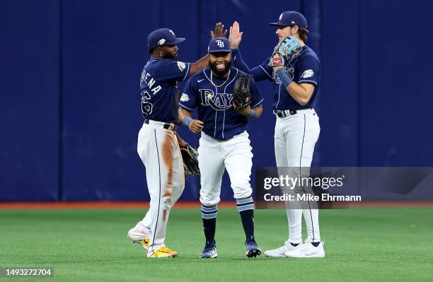 Randy Arozarena, Manuel Margot, and Josh Lowe of the Tampa Bay Rays celebrate after winning a game against the Toronto Blue Jays at Tropicana Field...