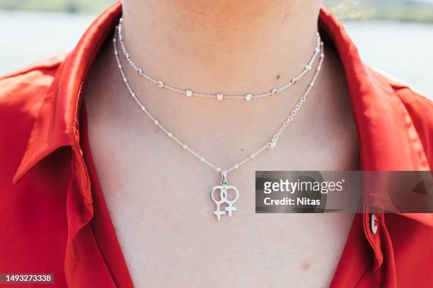 unrecognizable young woman with a necklace of the feminist symbol - choker necklace stock pictures, royalty-free photos & images