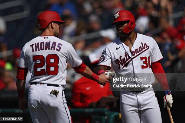 Lane Thomas of the Washington Nationals celebrates with teammate Stone Garrett after scoring a run against the San Diego Padres during the first...