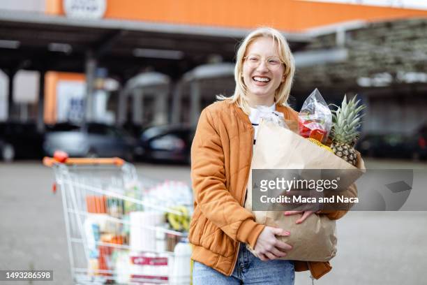 porträt einer frau nach dem supermarkteinkauf - shopping cart stock-fotos und bilder