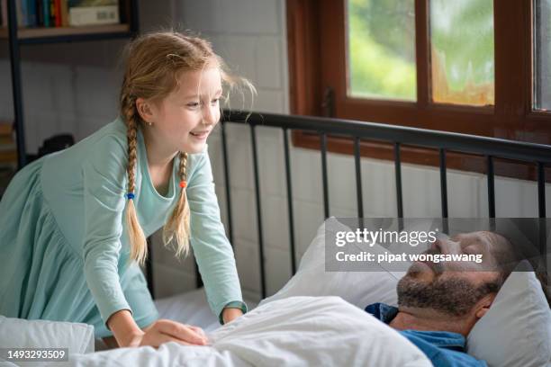 daughter waking up sleepy father in bed - shaking stock pictures, royalty-free photos & images