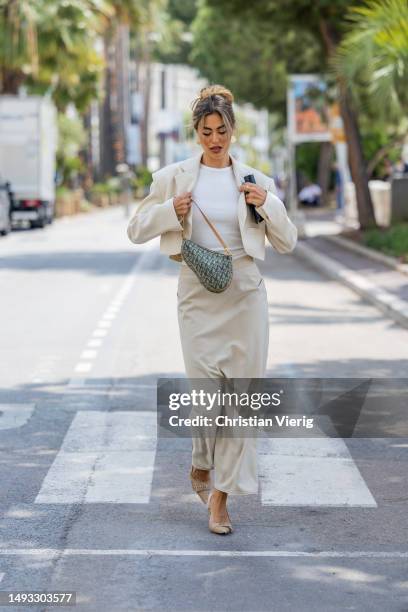 Jessica De Oliveira wears beige cropped blazer, skirt, white shirt Source Unknown, brown heels, Dior bag during the 76th Cannes film festival on May...