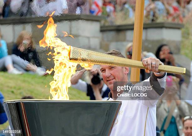 In this handout image provided by LOCOG, Olympic Gold Medalist rower Torchbearer 011 Matthew Pinsent lights the cauldron with the Olympic Flame on...