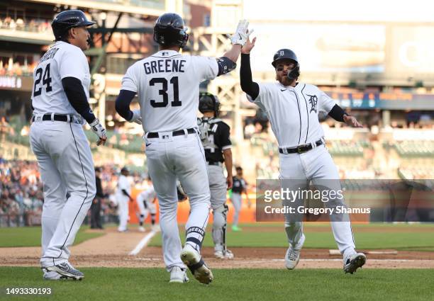 Eric Haase of the Detroit Tigers celebrates scoring a run in the fourth inning with Riley Greene and Miguel Cabrera of the Detroit Tigers while...