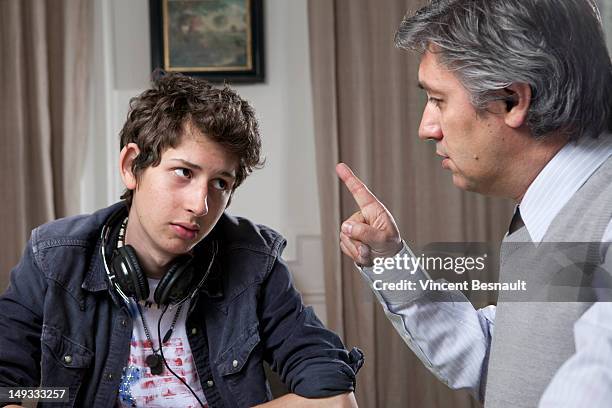 a teenage boy being told off by his father - strict parent stock-fotos und bilder