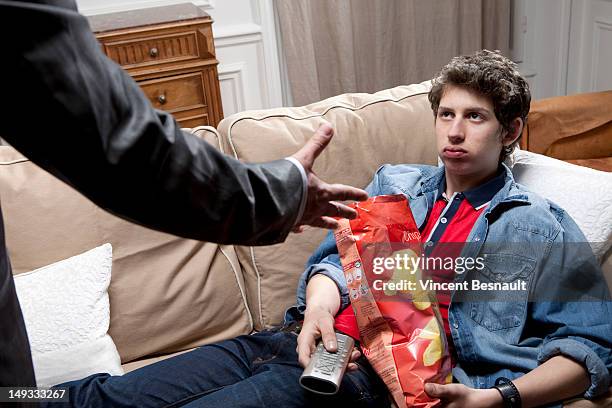 a loafing teenager being yelled at by his father - luiheid stockfoto's en -beelden