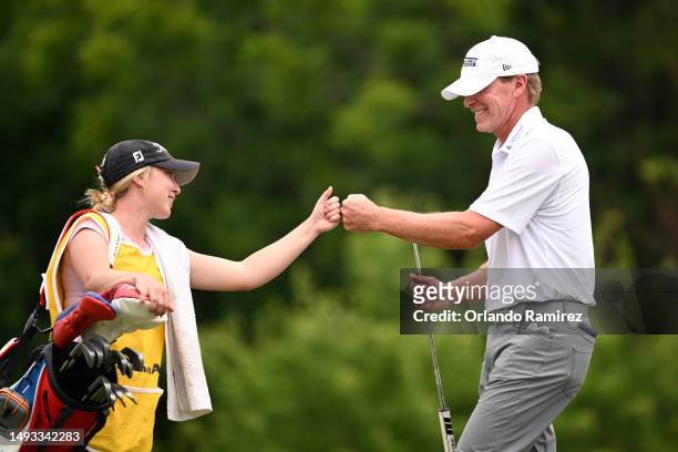 Steve Stricker celebrates with his caddie after a putt on the 13th green during the first round of the KitchenAid Senior PGA Championship at Fields...