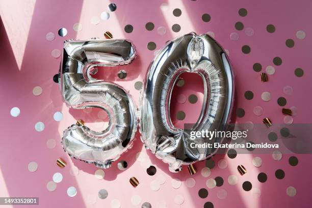 silver numbers 50 fifty year balloons in sunlight pink background - number 50 imagens e fotografias de stock