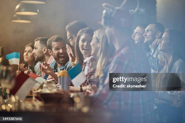 large group of happy people talking in a bar. - club de football imagens e fotografias de stock